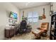 Comfortable home office has a recliner, guitars on the walls, and natural light at 16211 Cayman Ln, Punta Gorda, FL 33955