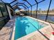 Inviting screened-in pool area with lounge chairs and umbrellas, offering relaxation with a view of the tranquil waterfront at 16211 Cayman Ln, Punta Gorda, FL 33955
