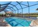 Relaxing screened-in pool area with comfortable lounge furniture overlooking the water at 16211 Cayman Ln, Punta Gorda, FL 33955