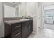 Bathroom with dark vanity, granite countertop, and tile flooring, offering a clean and modern look at 16621 Sunburst Lake St, Wimauma, FL 33598