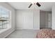 Bright bedroom with a ceiling fan, window with blinds, and ample closet space at 16621 Sunburst Lake St, Wimauma, FL 33598