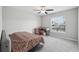 Well-lit bedroom featuring a ceiling fan, desk, and window offering natural light and comfort at 16621 Sunburst Lake St, Wimauma, FL 33598