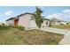 Tan home with a red front door, complemented by a well-maintained lawn and fresh landscaping at 16621 Sunburst Lake St, Wimauma, FL 33598