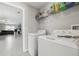 Laundry room with modern appliances; open floorplan with view to living room at 16621 Sunburst Lake St, Wimauma, FL 33598