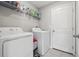 Functional laundry room featuring a washer, dryer, and overhead storage at 16621 Sunburst Lake St, Wimauma, FL 33598