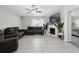 Spacious living room with tile floors, ceiling fan, fireplace and comfortable sofas at 16621 Sunburst Lake St, Wimauma, FL 33598