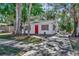 Charming single-story home with white siding, a bright red door, and mature landscaping at 1664 10Th St, Sarasota, FL 34236