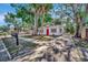 Charming home with a red door, surrounded by mature trees and a well-manicured lawn at 1664 10Th St, Sarasota, FL 34236