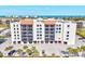 Exterior of the complex, with balconies and a parking area surrounded by palm trees and landscaping at 1945 Gulf Of Mexico Dr # M2-110, Longboat Key, FL 34228