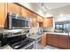 Updated kitchen featuring stainless steel appliances, granite countertops, and warm wood cabinetry at 1945 Gulf Of Mexico Dr # M2-110, Longboat Key, FL 34228
