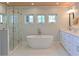 Bathroom featuring freestanding tub, walk-in shower, dual sink vanity, and marble floors at 206 23Rd W St, Bradenton, FL 34205