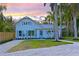 Charming two-story home with a gravel driveway, light blue shutters, and lush tropical landscaping at 206 23Rd W St, Bradenton, FL 34205