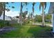 The front yard is green, with palm trees lining the driveway and a view of neighborhood houses at 206 23Rd W St, Bradenton, FL 34205
