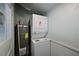 Compact laundry room featuring a stacked washer and dryer unit and a water heater at 206 23Rd W St, Bradenton, FL 34205