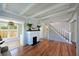 Cozy living room showcasing a painted brick fireplace, hardwood floors, and a staircase at 206 23Rd W St, Bradenton, FL 34205