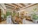 Elegant dining room with a long wooden table, chandelier lighting, and views of the outdoors at 2161 Gulf Of Mexico Dr # 6, Longboat Key, FL 34228