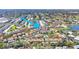 An aerial shot shows the property among beautiful trees, a lake, and a community pool at 2446 Clubhouse Cir # 202, Sarasota, FL 34232