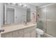 Bright bathroom featuring a marble vanity top, mirror and glass enclosed shower at 2446 Clubhouse Cir # 202, Sarasota, FL 34232