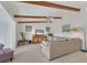Bright living room featuring beamed ceilings, a neutral sofa, and a sliding glass door to a balcony at 2446 Clubhouse Cir # 202, Sarasota, FL 34232