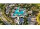 Overhead shot of a large community pool area featuring a freeform pool, seating, and lush landscaping at 26800 Pavin Dr, Englewood, FL 34223