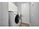 Laundry room area featuring front load washer and dryer with cabinets at 26800 Pavin Dr, Englewood, FL 34223
