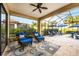 An outdoor screened patio with cushioned seating, ceiling fan, and view to a pool at 26800 Pavin Dr, Englewood, FL 34223