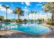 Beautiful community pool with clear blue water surrounded by palm trees and seating areas at 26800 Pavin Dr, Englewood, FL 34223