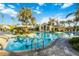 Expansive community pool area with lounge chairs, tropical landscaping, and community building at 26800 Pavin Dr, Englewood, FL 34223