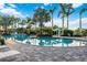 Large community pool featuring chairs, umbrellas and lush tropical landscaping in the background at 26800 Pavin Dr, Englewood, FL 34223