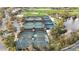 Aerial view of tennis courts with multiple green courts, surrounded by trees in a community setting at 26800 Pavin Dr, Englewood, FL 34223