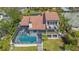 Aerial view of a home featuring a beautiful tiled roof, screened-in pool, and private access to the water at 3151 Bayou Sound, Longboat Key, FL 34228