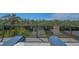 View from balcony with glass railing, overlooking lush greenery with 2 lounge chairs and a small table at 3151 Bayou Sound, Longboat Key, FL 34228