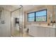 Well-lit bathroom with a tiled glass shower and vanity with white cabinets and countertops at 3151 Bayou Sound, Longboat Key, FL 34228