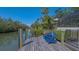 Private dock on a canal with two bright blue Adirondack chairs offering a tranquil waterfront experience at 3151 Bayou Sound, Longboat Key, FL 34228
