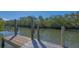 Dock with wooden pilings provides boating access to a tranquil waterway surrounded by lush greenery at 3151 Bayou Sound, Longboat Key, FL 34228