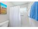 Bright bathroom with white tile and a shower featuring a curtain and grab bars at 3424 90Th N Ter, Pinellas Park, FL 33782