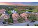 Aerial view of homes with red tile roofs, manicured lawns, and a tranquil pond in a residential community at 3715 80Th E Dr, Sarasota, FL 34243