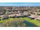 A birds-eye view of the house with a serene pond, complemented by mature trees and lush landscaping at 3715 80Th E Dr, Sarasota, FL 34243