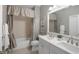 Bathroom featuring a double sink vanity with a white countertop and white cabinets, complemented by a tub and decorative curtains at 3715 80Th E Dr, Sarasota, FL 34243