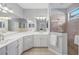 Bathroom featuring double sinks, quartz counters, and a glass enclosed walk-in shower at 3715 80Th E Dr, Sarasota, FL 34243