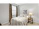 Bedroom featuring a bed with neutral patterned bedding, side table with lamp, and window with curtain letting in natural light at 3715 80Th E Dr, Sarasota, FL 34243