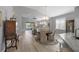 Open concept dining area with wood floors, chandelier, and views of the living room and water outside at 3715 80Th E Dr, Sarasota, FL 34243