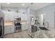 Bright kitchen featuring stainless steel appliances, mosaic tile backsplash, granite counters, and white cabinetry at 3715 80Th E Dr, Sarasota, FL 34243