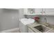 Laundry room with white washer and dryer, gray countertop, stainless steel sink, and white cabinets offering storage at 3715 80Th E Dr, Sarasota, FL 34243
