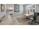Office with a large window, plantation shutters, desk, modern chair, and sofa at 3715 80Th E Dr, Sarasota, FL 34243