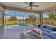 Relaxing screened-in patio with comfortable seating and a view of the pool and lake at 3715 80Th E Dr, Sarasota, FL 34243