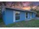 Side view of a blue single-story home with white trim, large windows, and green grass at 4015 11Th W Ave, Bradenton, FL 34205