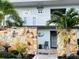 Building entrance with stone accent wall surrounded by tropical landscaping at 4240 Ironwood Cir # 302A, Bradenton, FL 34209