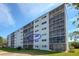 The building's exterior with large windows and balconies, surrounded by greenery and clear skies at 4240 Ironwood Cir # 302A, Bradenton, FL 34209