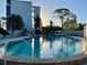 A shimmering community pool surrounded by lounge chairs and lush greenery at 4240 Ironwood Cir # 302A, Bradenton, FL 34209